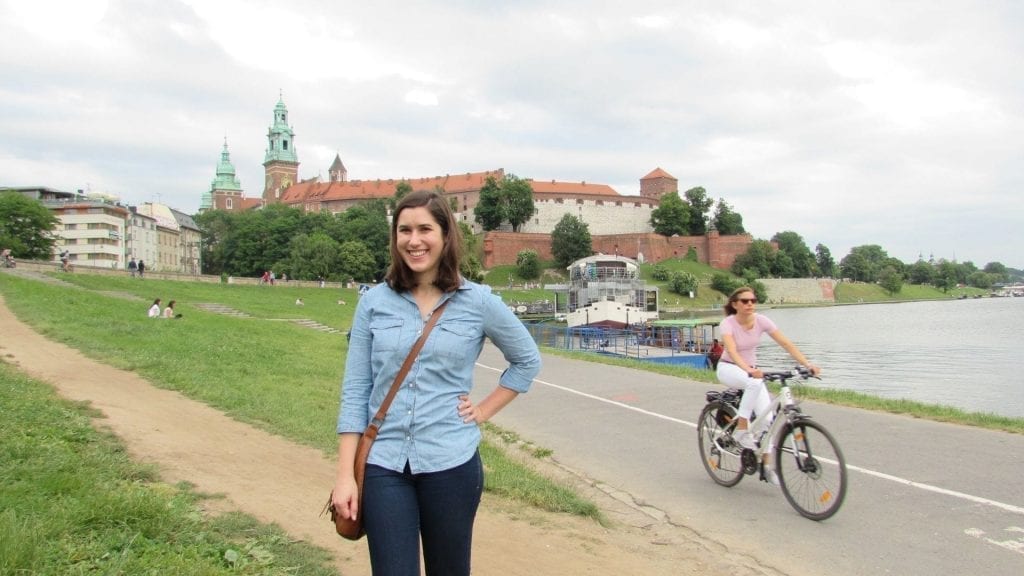 Kate Storm standing in front of Wawel Castle on the banks of the Vistula River when visiting Krakow Poland