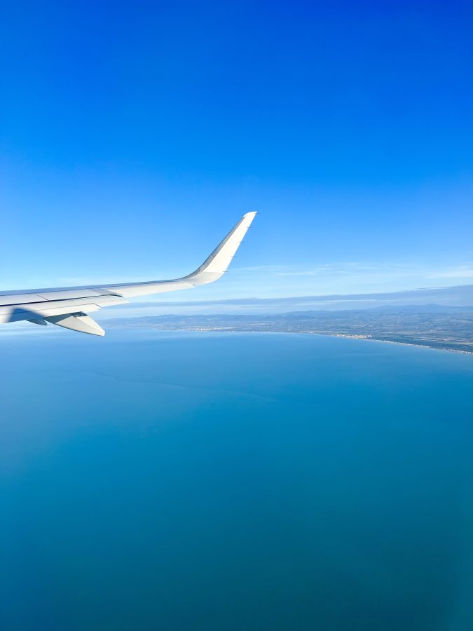 view of a plane wing over the mediterranean sea when leaving rome italy