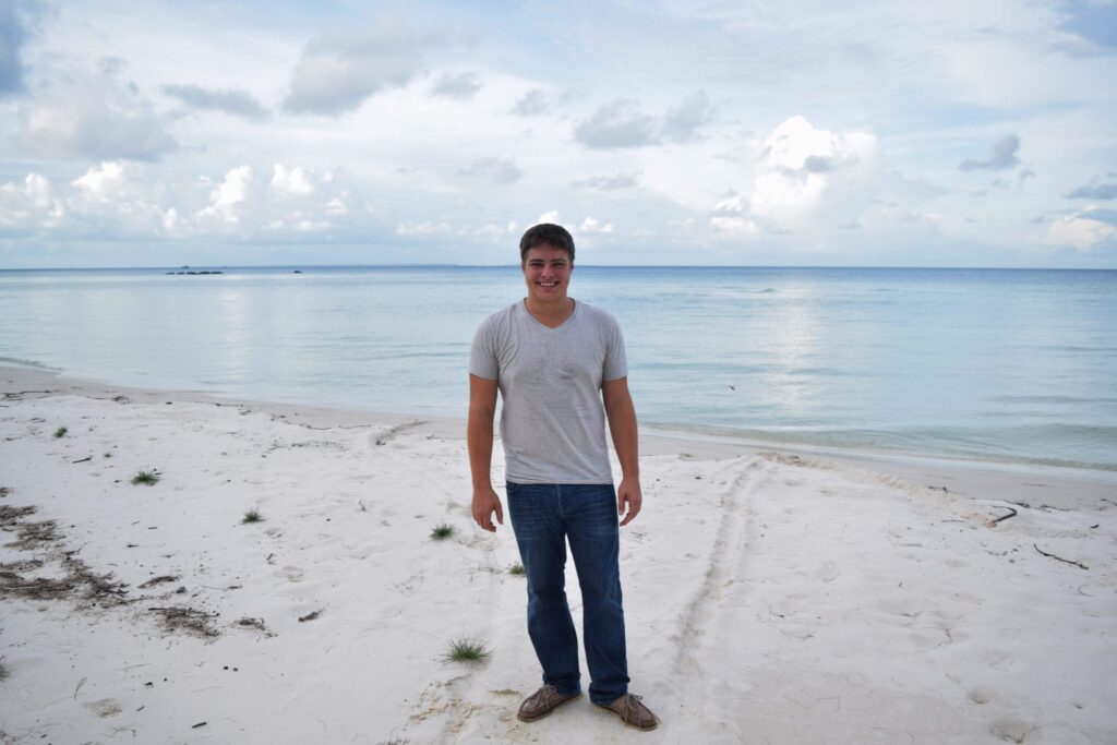 jeremy storm in a gray shirt standing on a beach on koh rong
