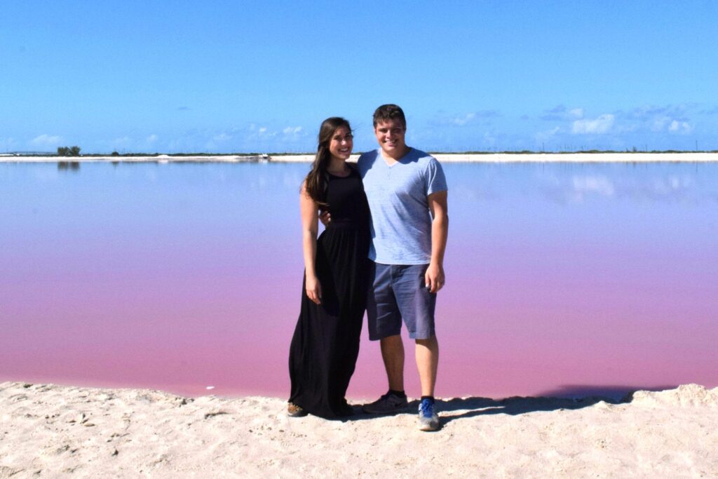 Kate Storm and Jeremy Storm standing in front of one a mexico pink lake las coloradas