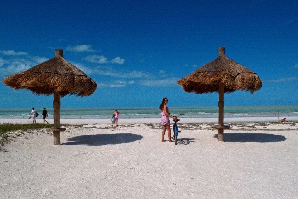Kate storm standing with a bike on the beach on isla holbox mexico things to do