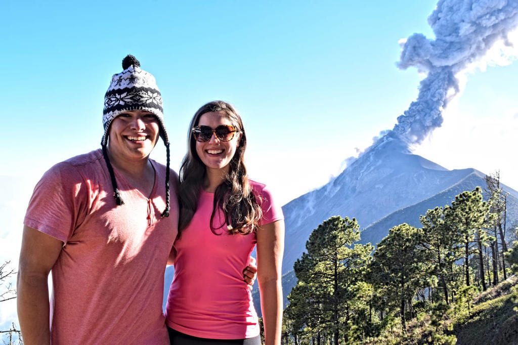 kate storm jeremy storm in front of erupting volcano fuego after hiking acatenango volcano