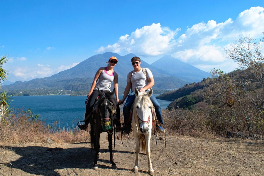 kate storm and jeremy storm riding horses along the shore of lake atitlan during a trip to guatemala