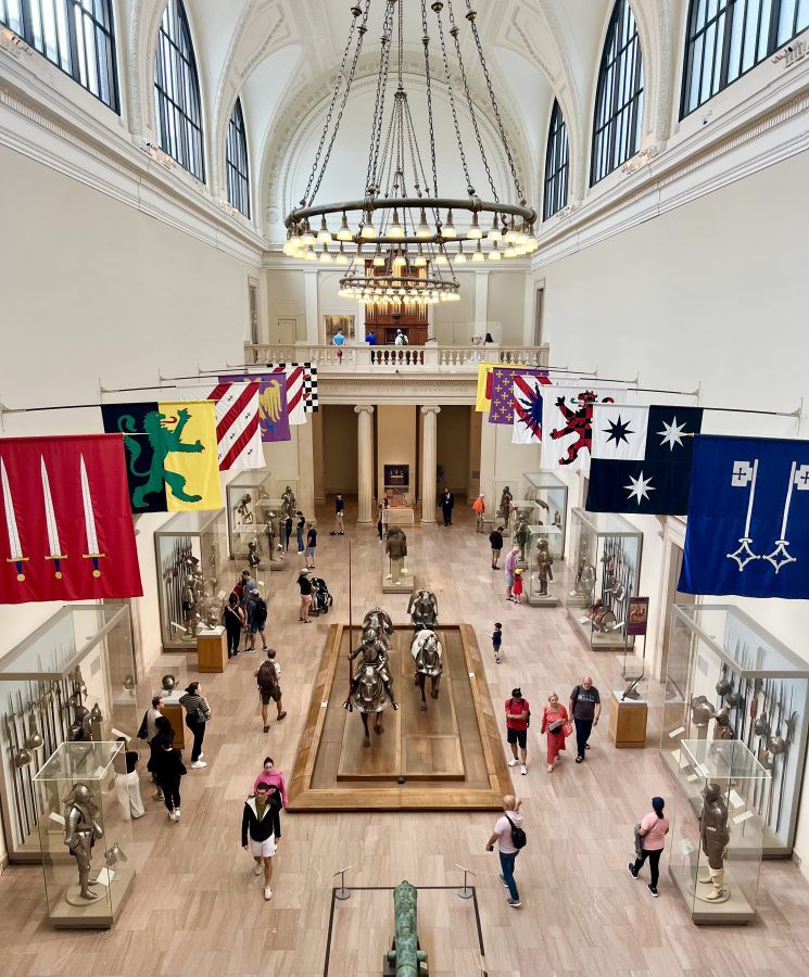 suits of armor and flags displayed at the met in new york city as seen from above