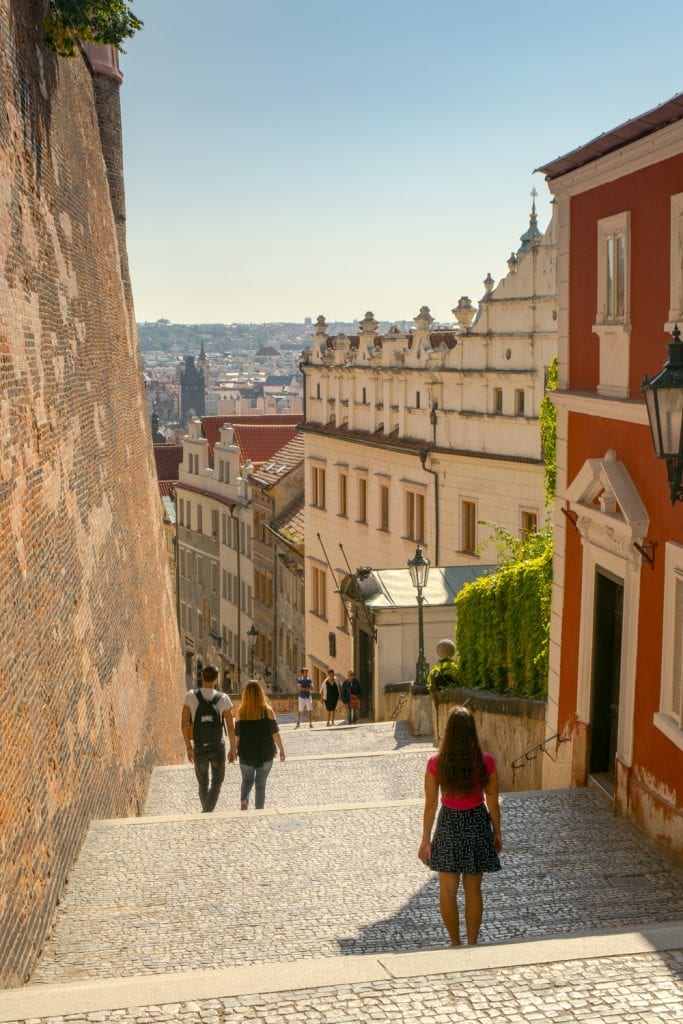 kate storm walking down a street near prague castle