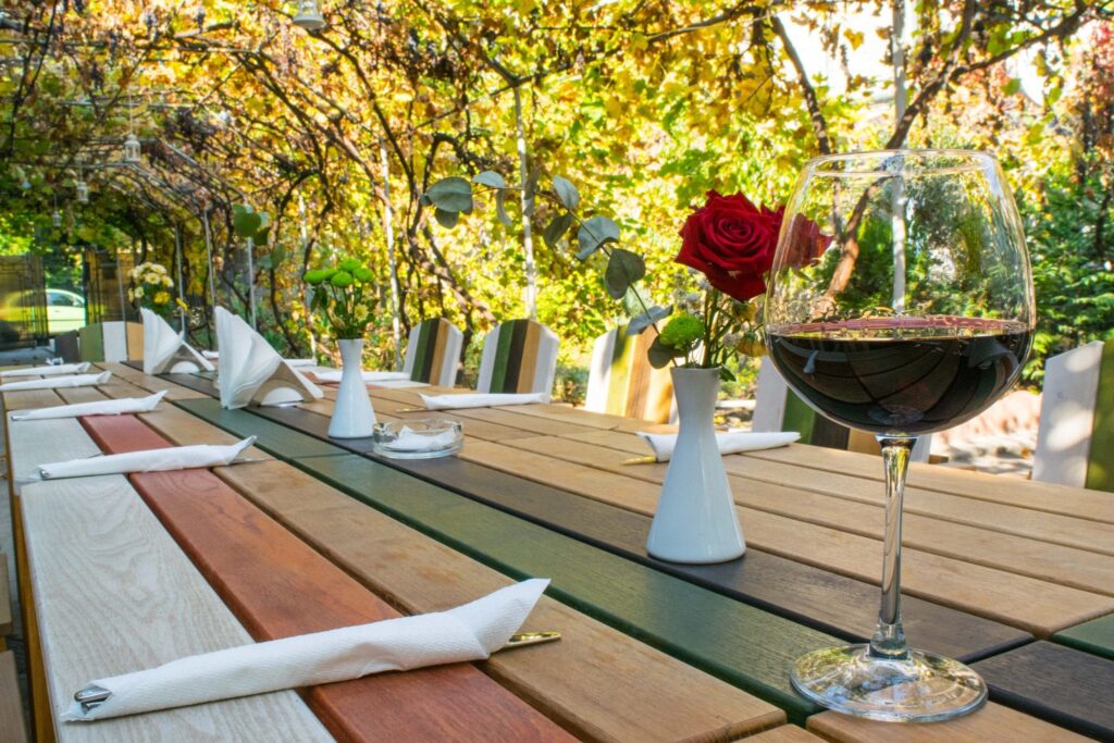 glass of red wine sitting on an outdoor dining table, as seen when visiting bucharest attractions