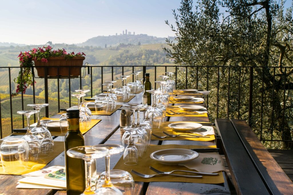 outdoor table set for wine tasting in tuscany with view of san gimignano in the background