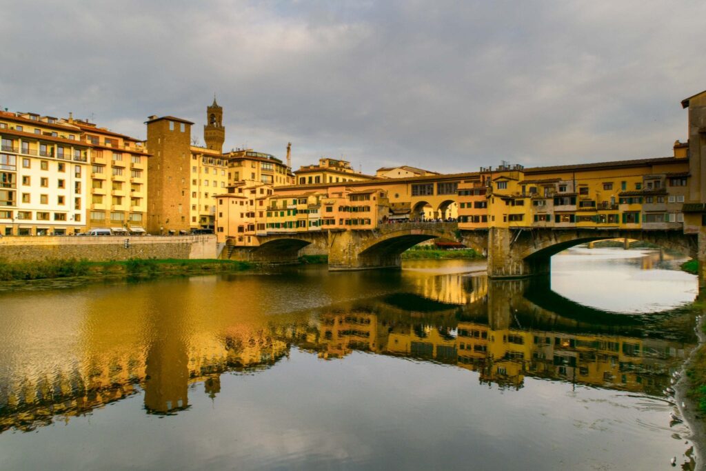 view of the ponte vecchio from in front of the hotel lungarno on a cloudy day in florence italy