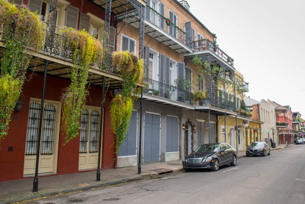 Quiet street in NOLA French Quarter with colorful buildings on the left side of the photo