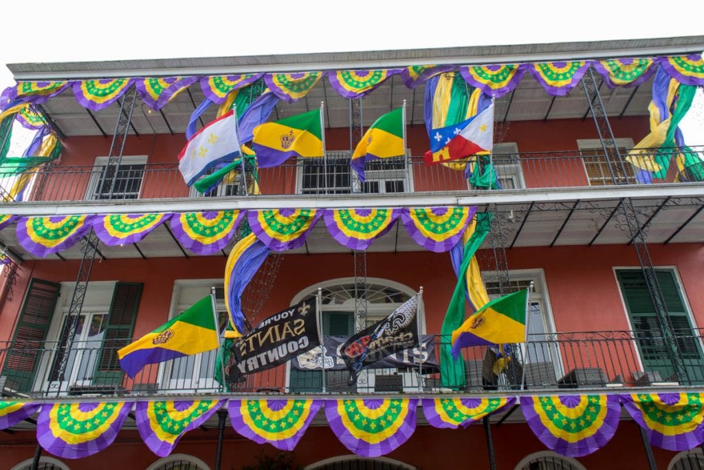 colletion of mardi gras flags hanging from balconies in the french quarter new orleans in january