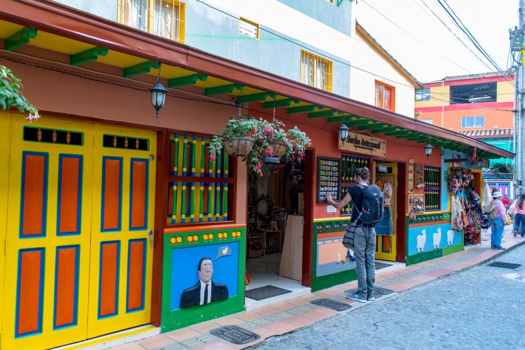 man looking at a menu outside a store in guatape colombia