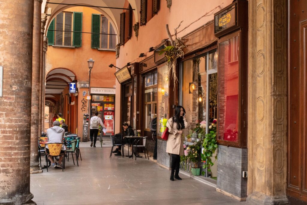 people standing under porticoes in bologna in a day