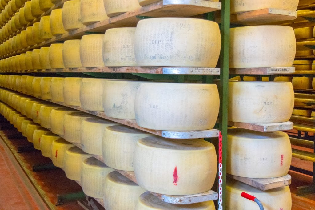 wheels of aging parmigiano-reggiano in a factory, one of the best things to do in emilia romagna
