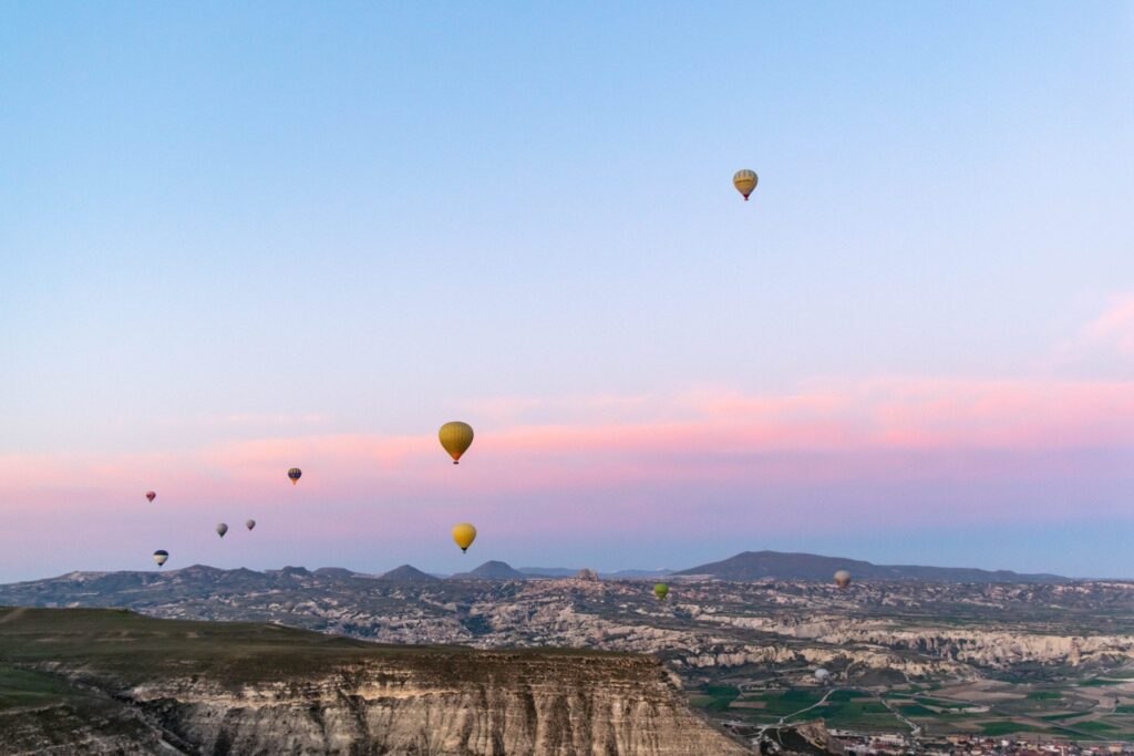 balloons rising over pink and purple sunrise
