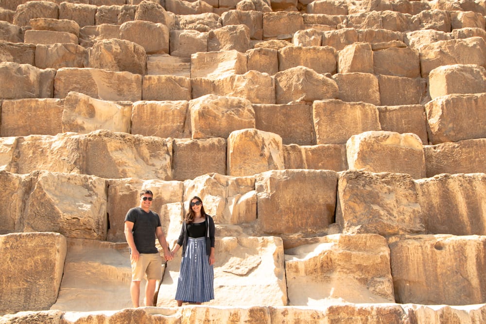 kate storm and jeremy storm holding hands on the great pyramid of giza in cairo egypt