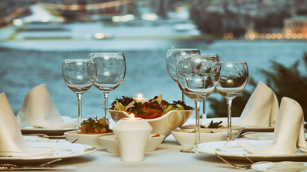 table set for dinner with wine glasses on a bosphorus dinner cruise