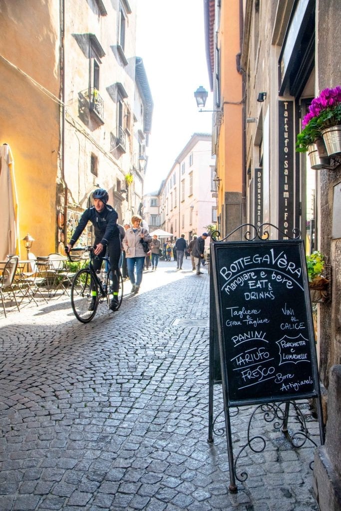 person on a bike riding through a side street when visiting orvieto italy