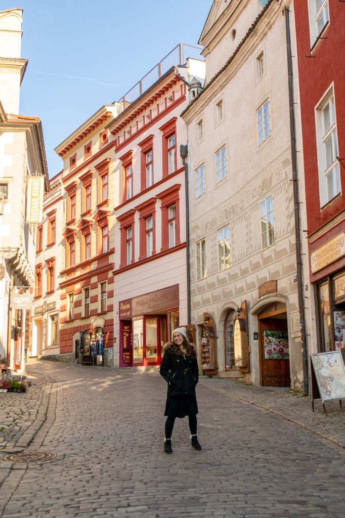 kate storm standing on an empty street in cesky krumlov in winter