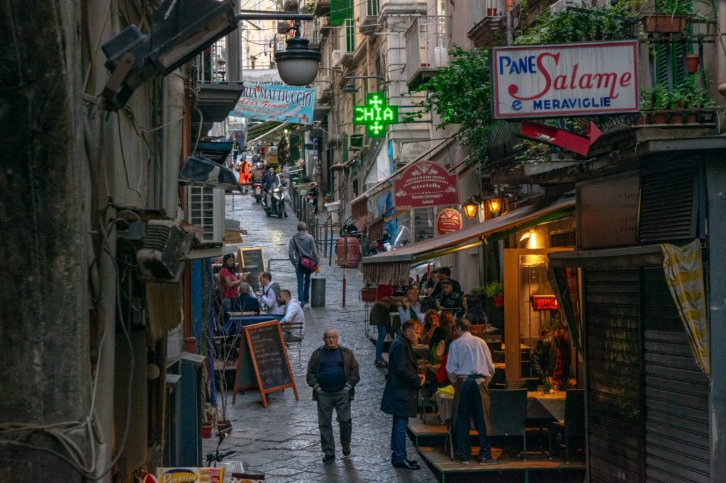 narrow street in naples italy crowded with people and street life