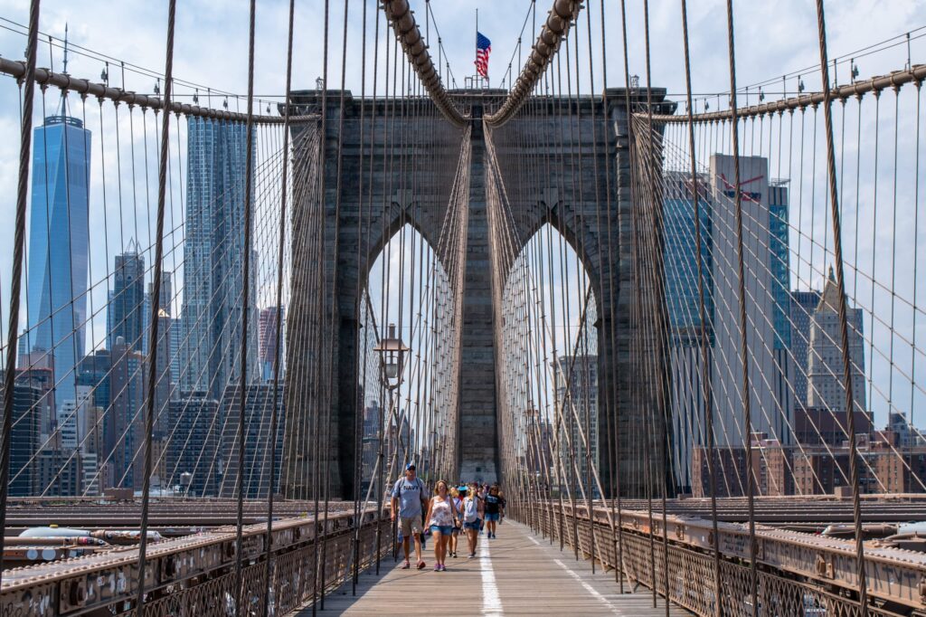 view from the center of the brooklyn bridge facing manhattan with skyscrapers in the background
