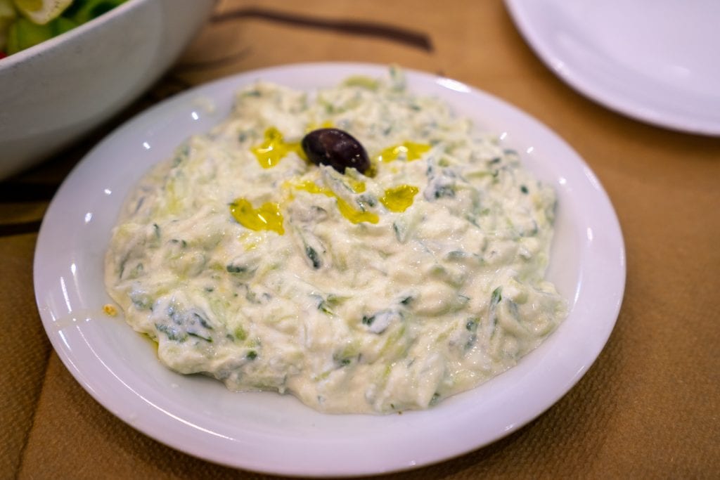tzatziki sauce served on a white place inside an athens restaurant taverna