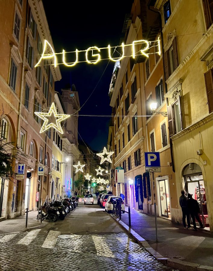 christmas lights strung along a small street in centro storico rome at night
