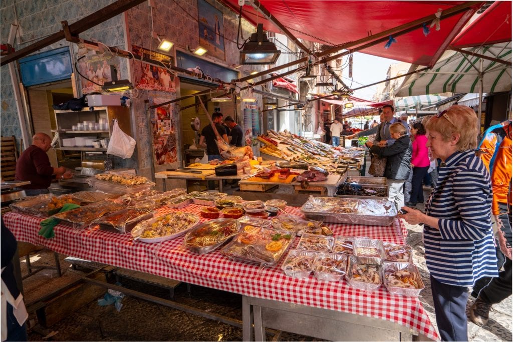 people shopping at a market stall in palermo sicily