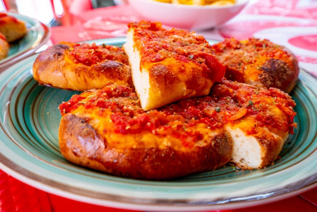 Sicilian pizza stacked on a green plate in Palermo