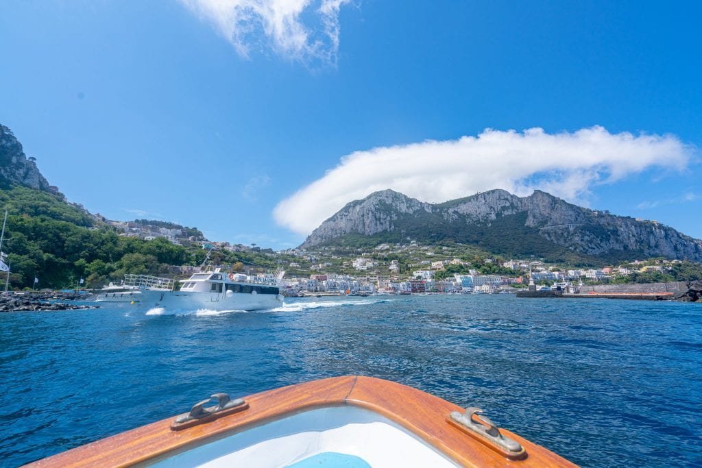 view of amalfi coast from afar with a bow of a small boat in the foreground, a great addition to a 7 day italy itinerary