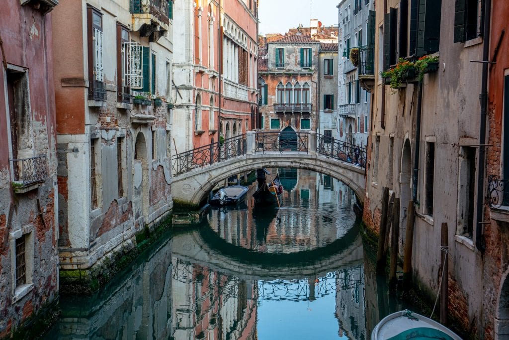 Footbridge reflecting into a quiet canal in Venice. Venice is a fascinating city and home to some very interesting facts about Italy