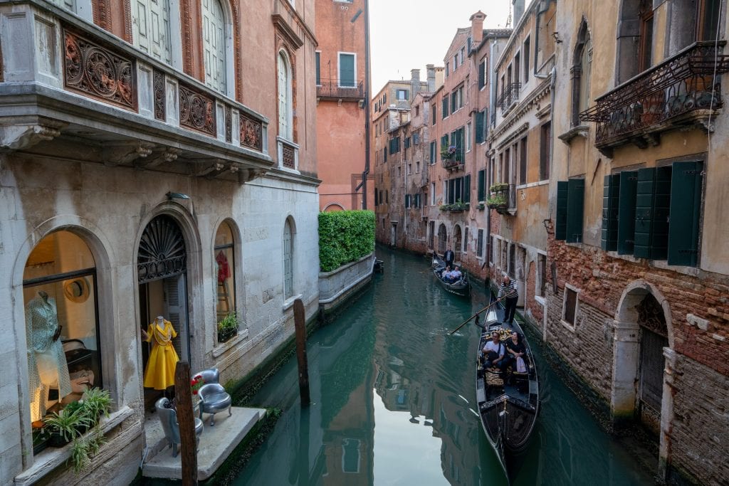 Photo of 2 gondolas in a small canal in Venice: if you hope to ride a gondola, definitely keep that in mind when choosing whether to visit Venice or Rome!