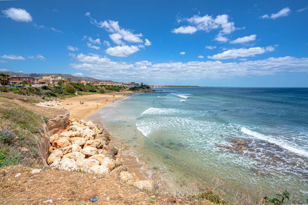 empty beach as seen on a sunny day in avola sicily with sea on the right side of the photo, as seen as part of a sicily road trip