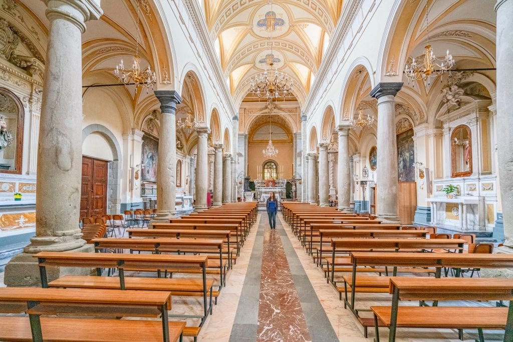 Kate Storm in a blue shirt standing in a church in Francavilla Sicily