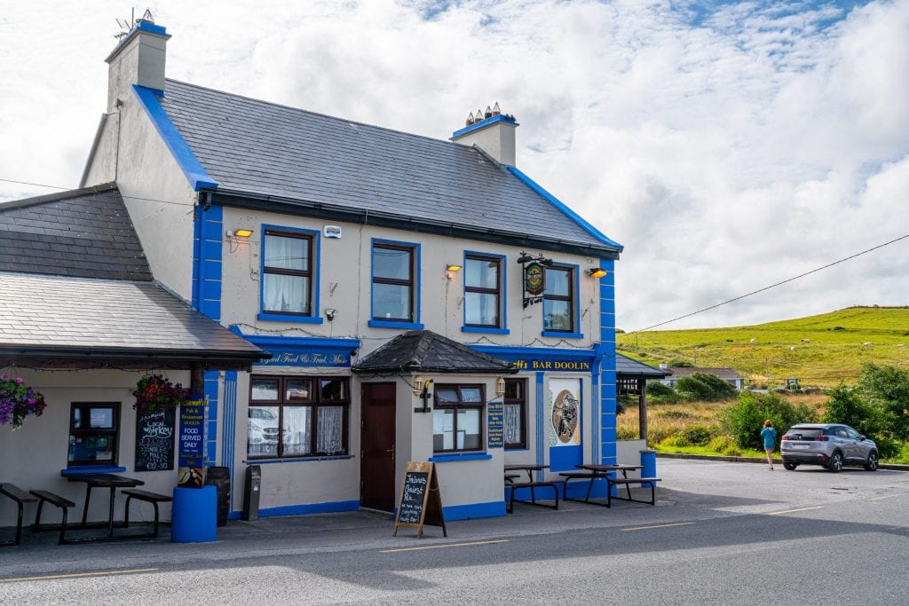Exterior McDermott's Pub in Doolin. The building is white with blue trim.