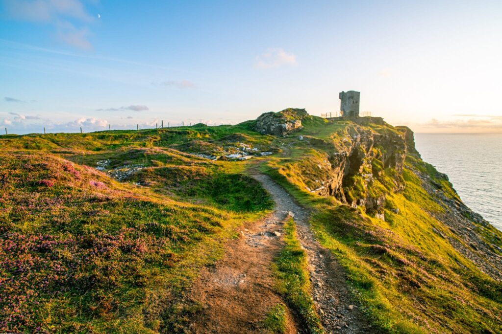 View of Hag's Head with Moher Tower on the right at sunset--definitely an experience worth having when visiting the Cliffs of Moher in Ireland!