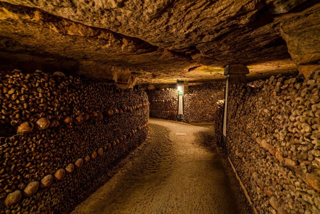 Empty path through the Paris catacombs with bones stacked on either side