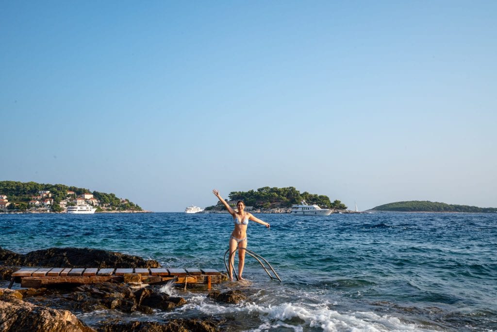 Kate Storm on a small dock on the edge of Hvar Croatia
