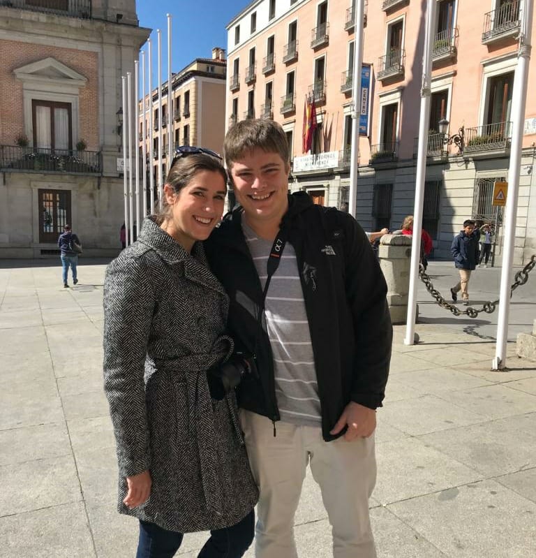 Kate Storm and Jeremy Storm standing in a square in Madrid Spain with a pink building behind them