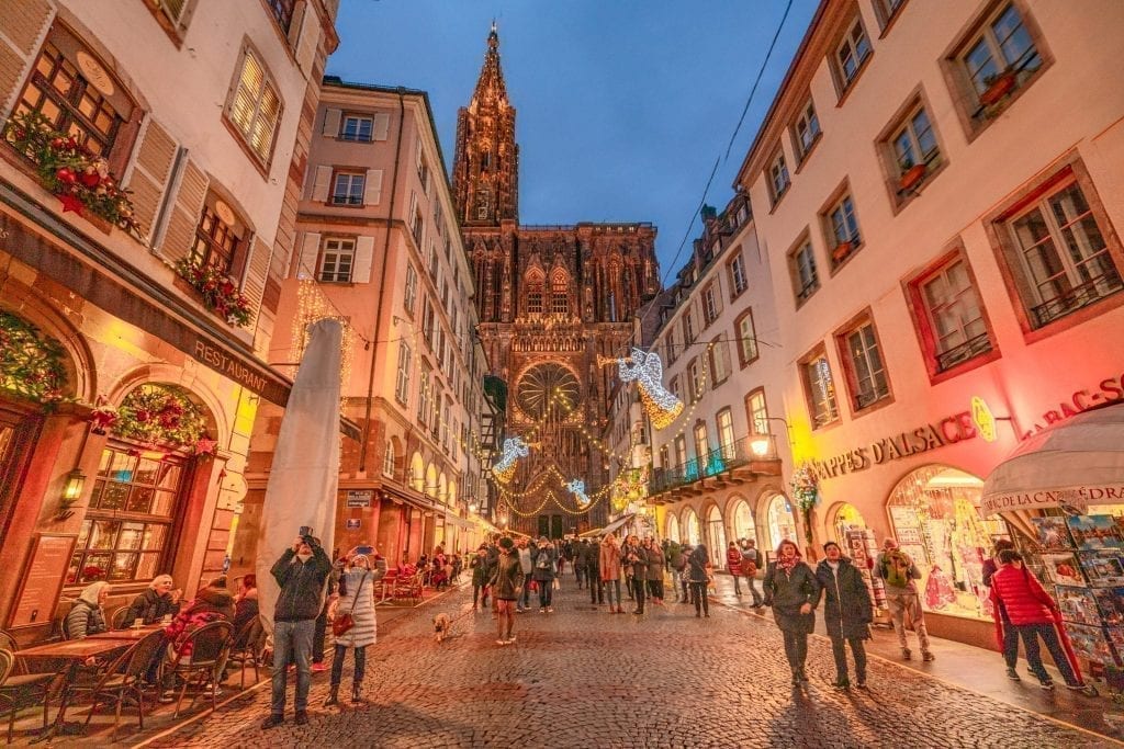 Street in Strasbourg France decorated for Christmas at blue hour, with the Strasbourg Cathedral in the background
