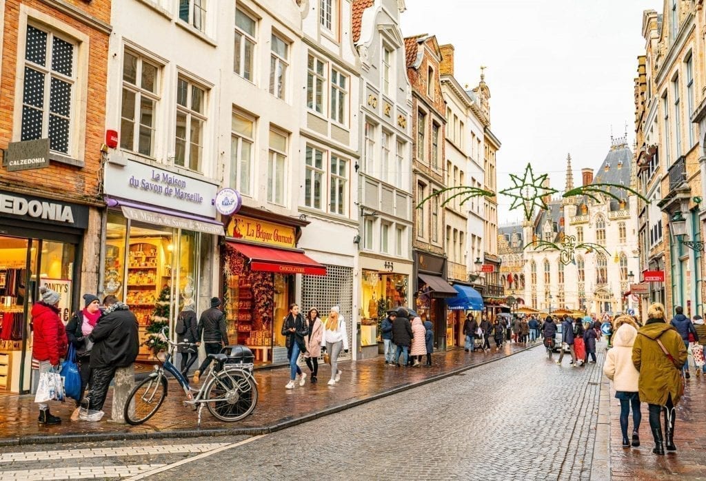 street scene in bruges in winter with christmas lights hanging across center