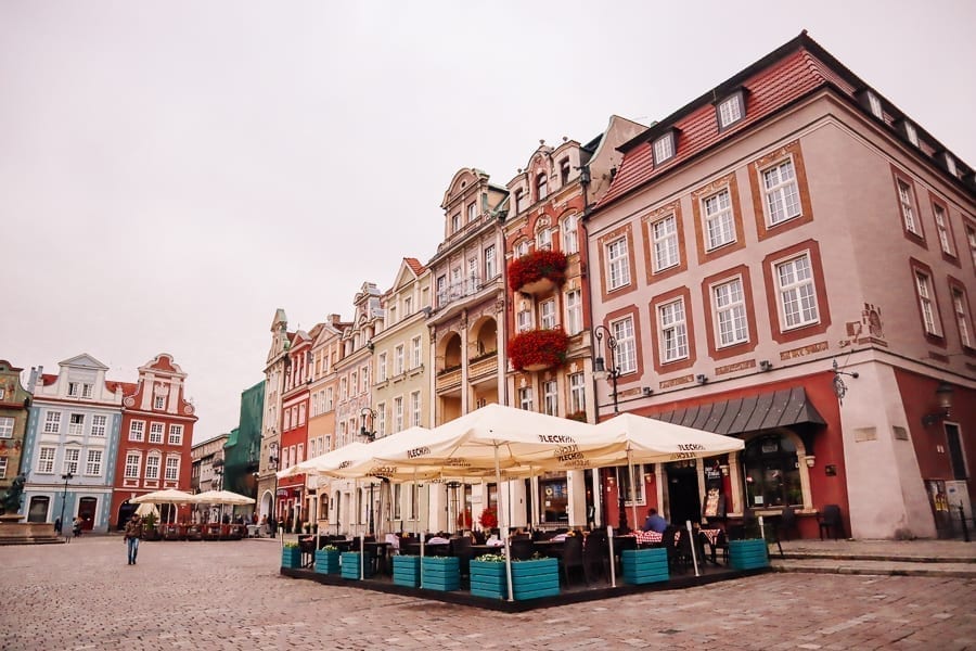 Colorful street in Poznan Poland with cafe visible in the foreground. Poznan is a great destination for those looking to explore Europe off the beaten path