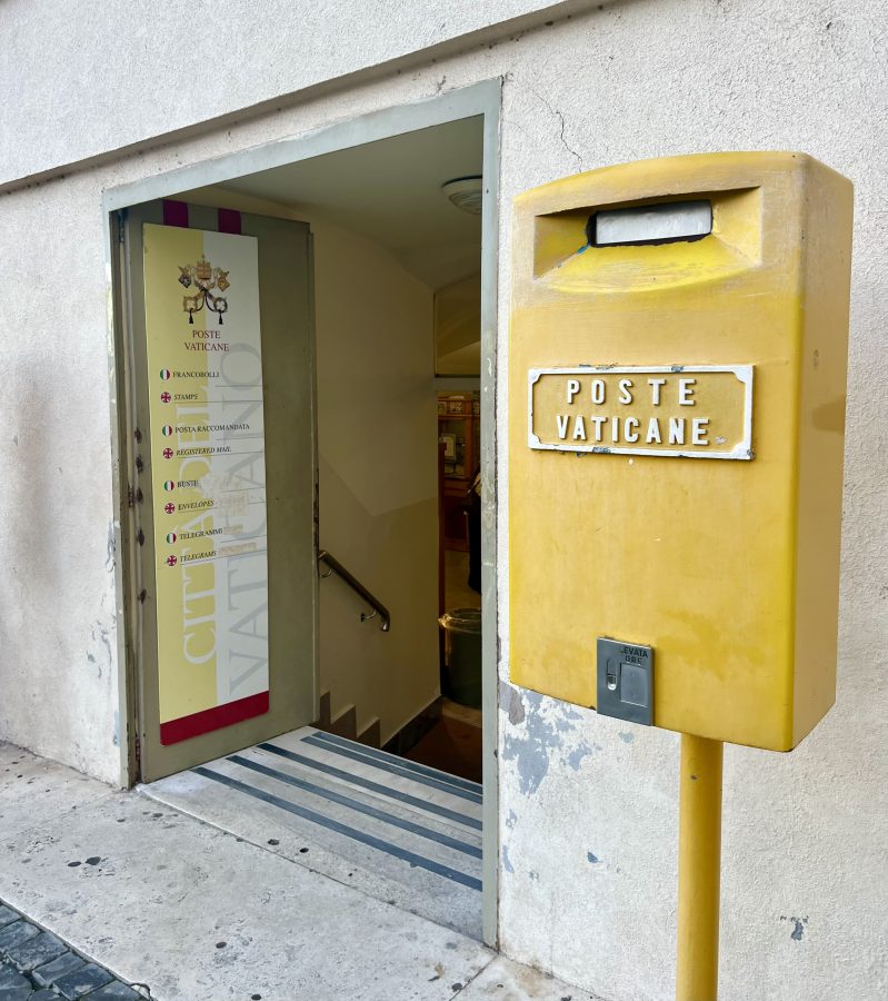 entrance to the vatican post office and yellow post office box in st peters square