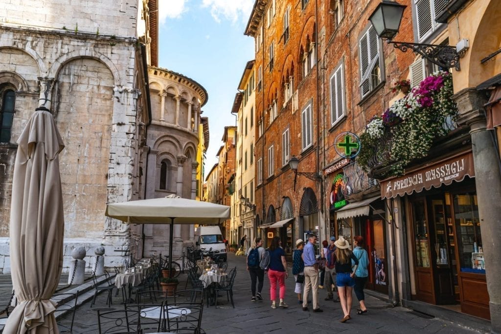 family walking through the shady streets of lucca historic center