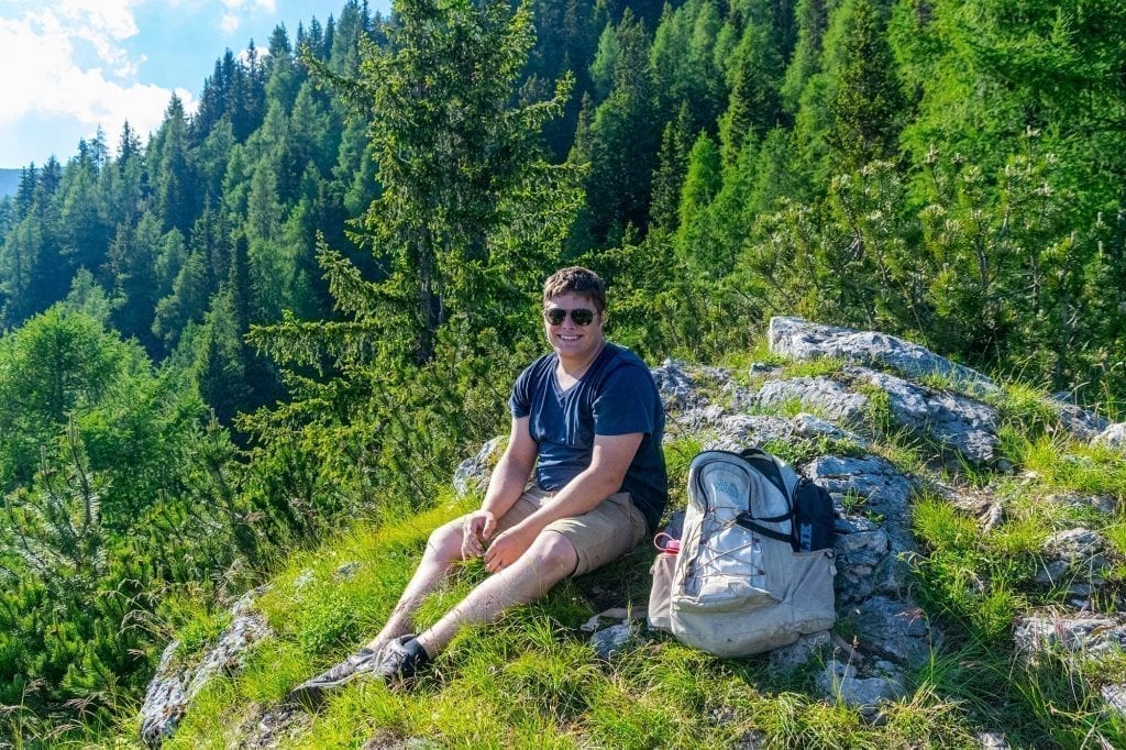 Jeremy Storm sitting on a forested trail in Slovenia