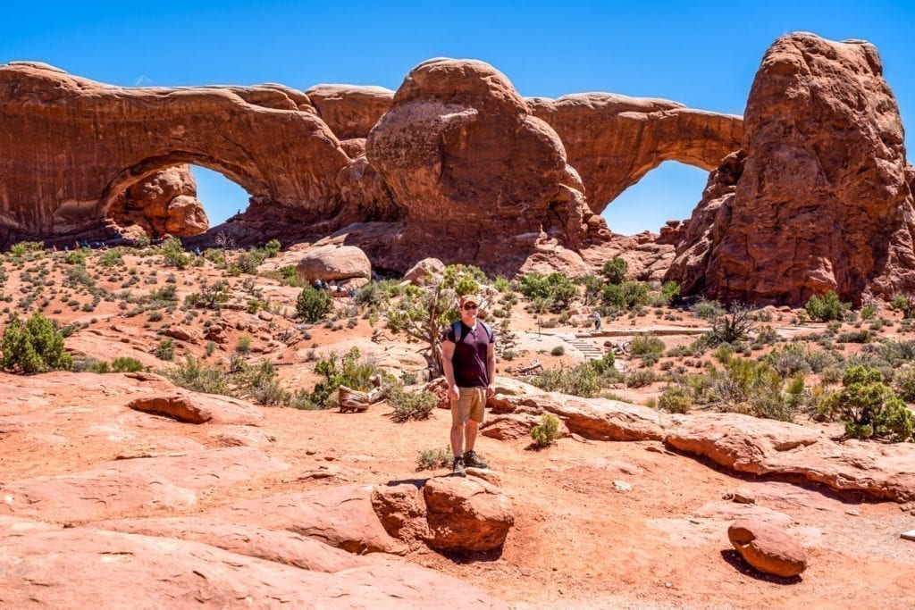 Jeremy Storm standing in front of the north and south windows in Arches, along one of the best hikes in Arches National Park