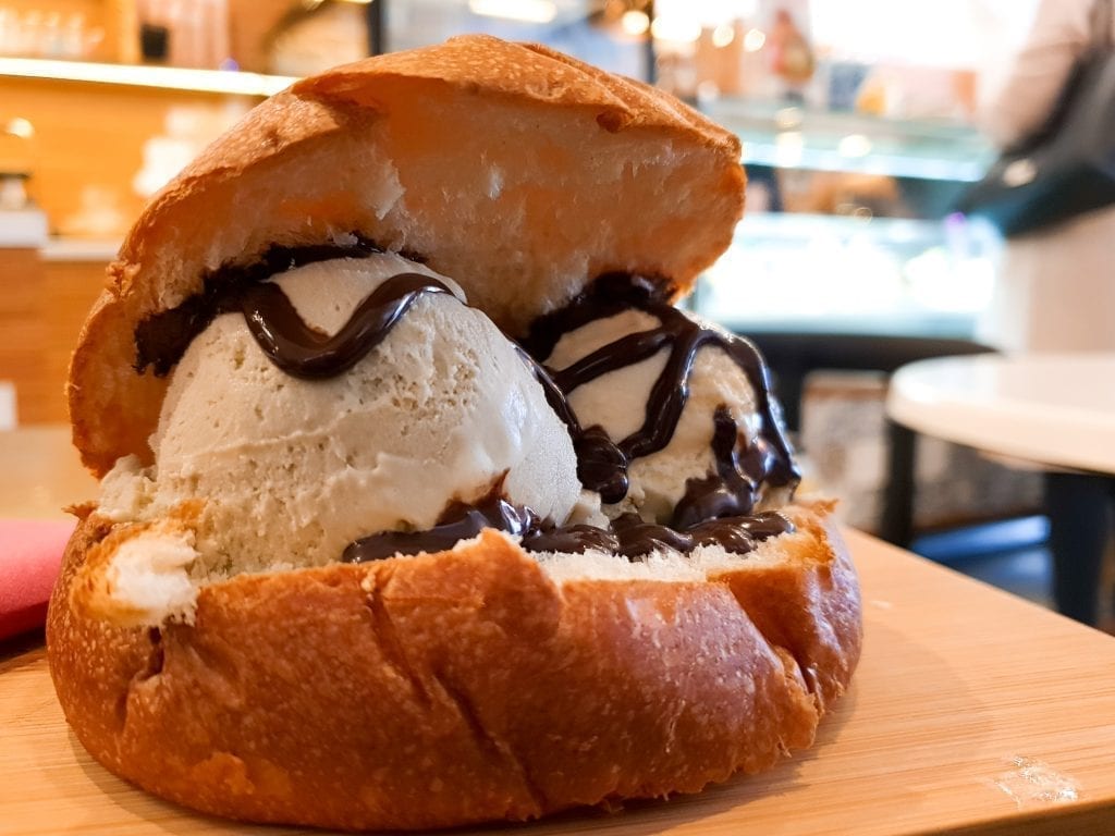 Brioche con gelato with chocolate sauce on it, a popular breakfast in Sicily