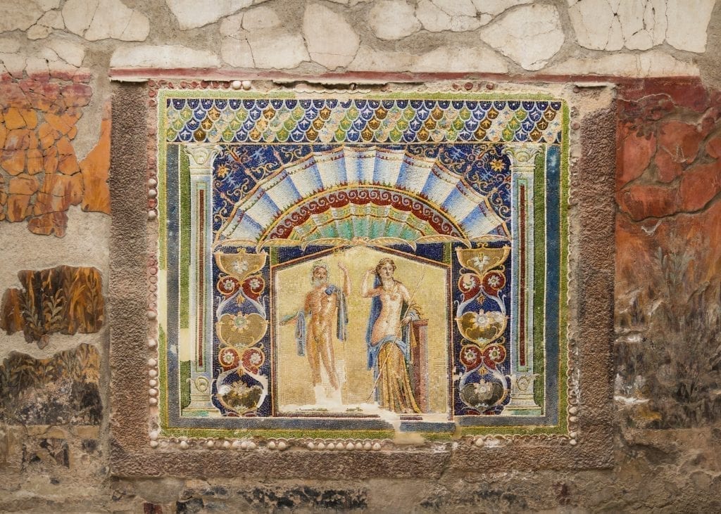 Fresco of two people on a wall inside a wall in Herculaneum--when deciding whether to visit Herculaneum or Pompeii, know that Herculaneum has better frescoes
