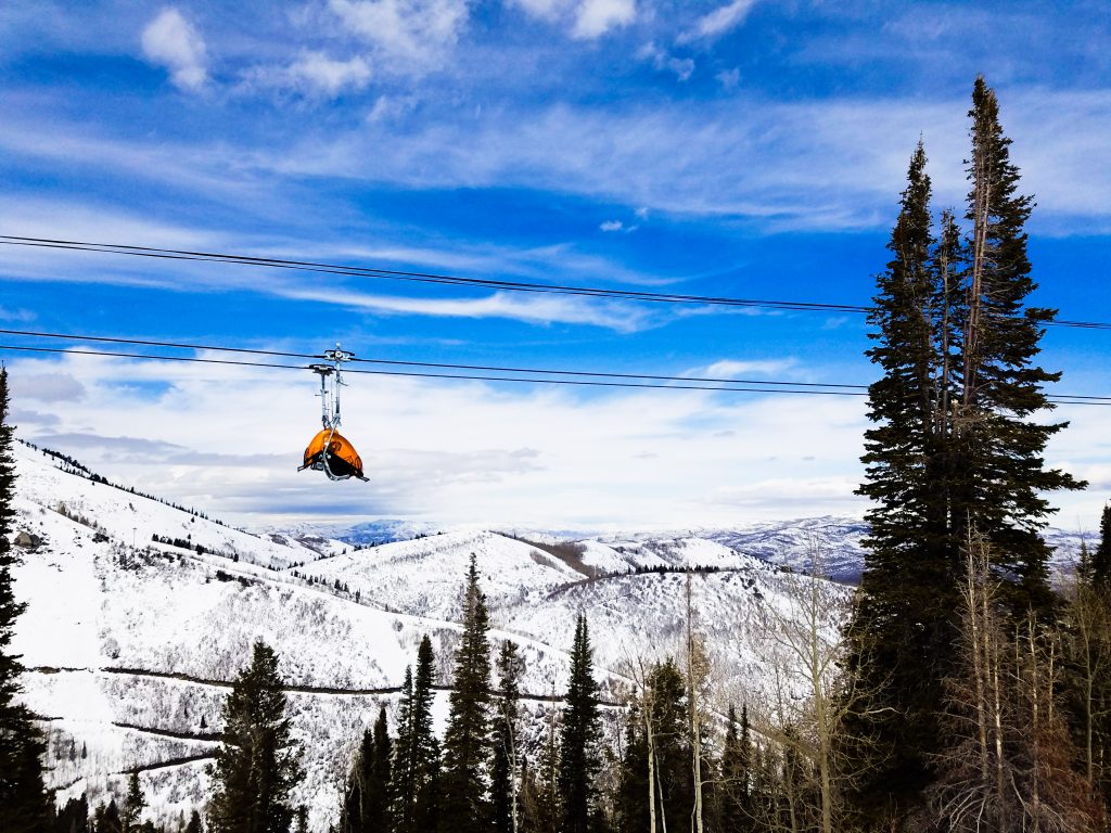 yellow ski lift in front of snowy mountains in park city utah, one of the top utah vacation destinations