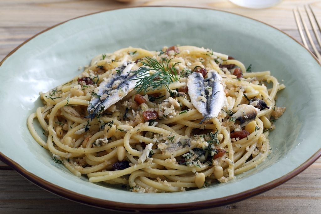 Pasta con le sarde in a light blue bowl, one of the best dishes in Sicilian cuisine