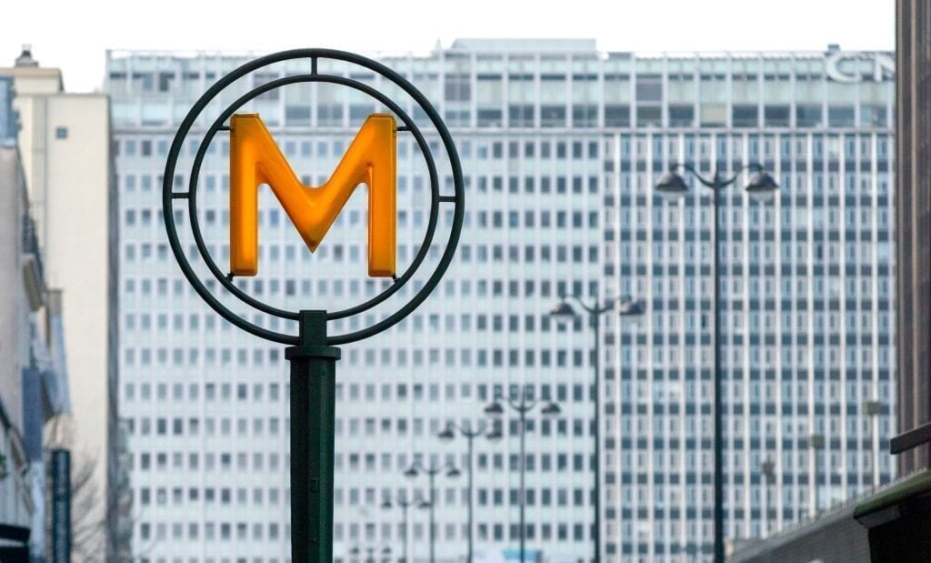 Yellow "M" sign denoting the Montparnasse-BienvenĂŒe metro station in Paris France